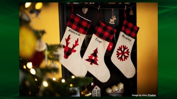 Three white and red christmas stockings hung on a wall for Christmas