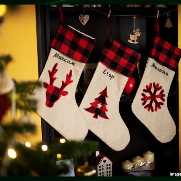 Three white and red christmas stockings hung on a wall for Christmas