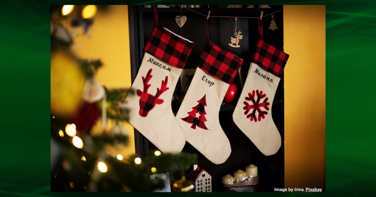 Three white and red christmas stockings hung on a wall for Christmas