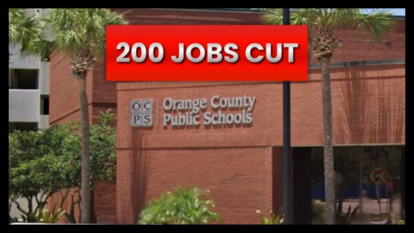 A sgn along a brick wall that reads orange county public schools